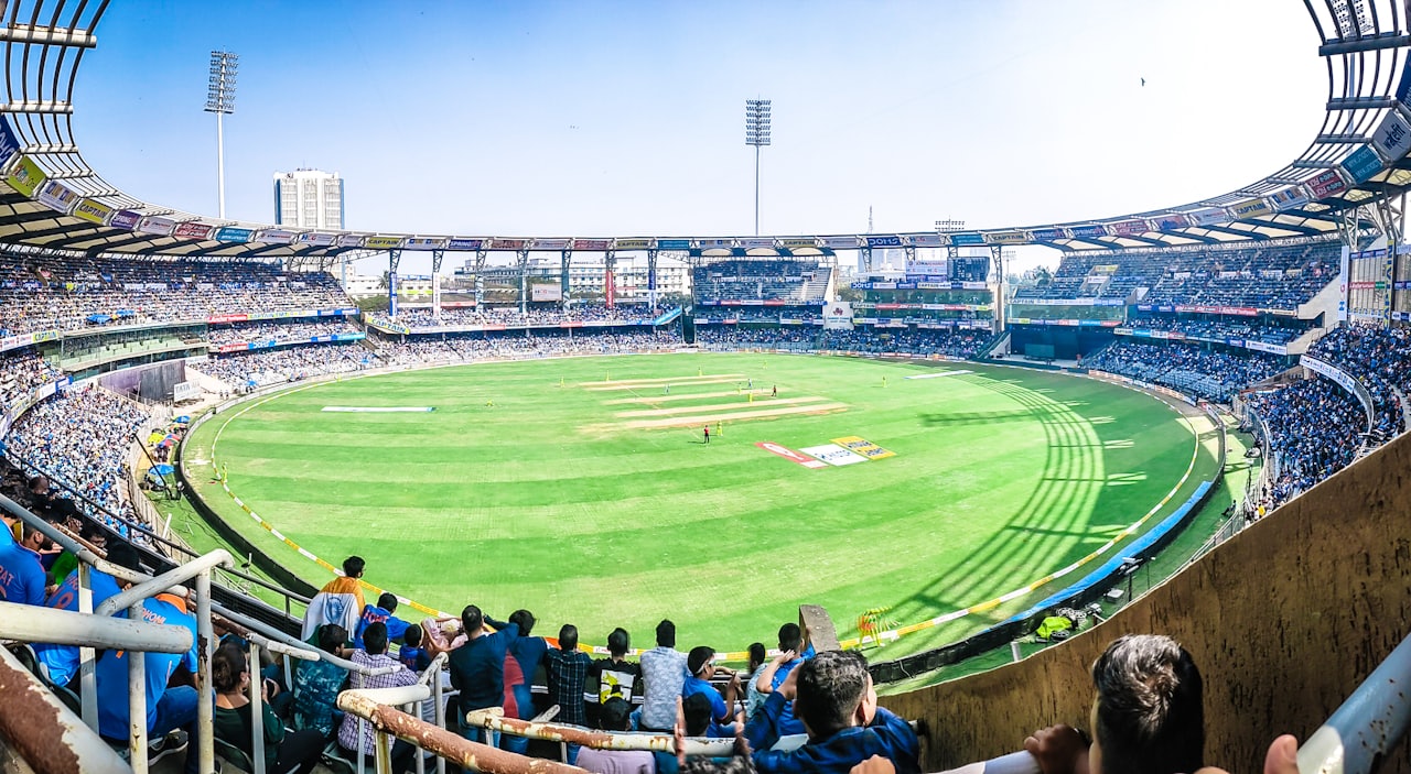 Cricket analysts reviewing player data on laptops