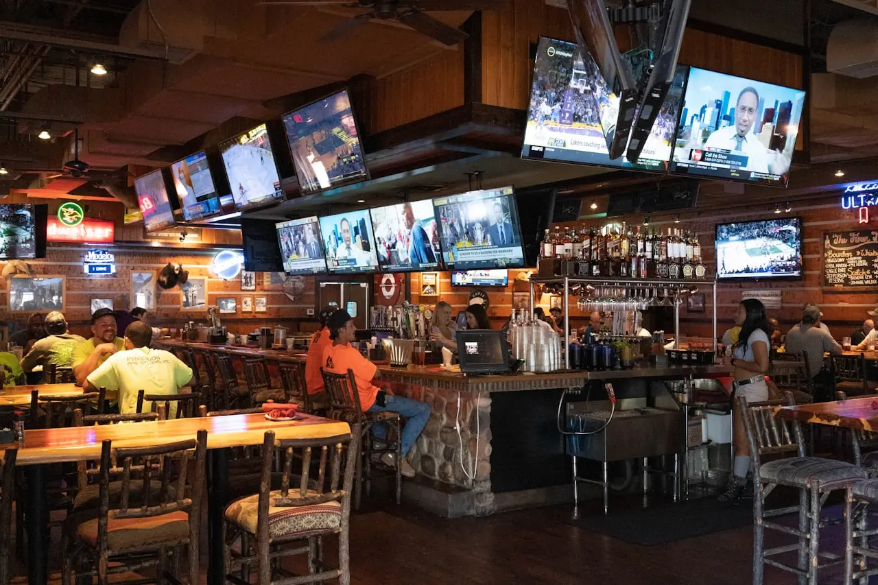 Fans watching live sports across multiple screens in a bar
